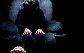 elderly woman sitting alone in the dark