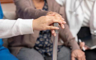 Close up of the hand of a nurse and aging woman.