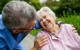 Senior resident and male nurse talking during walk outdoors.